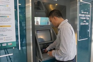 A cardholder is experiencing the use of a chip-based citizen ID card to withdraw money in Hanoi. 