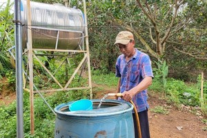 Vy Van Tuyen is taking clean water from the supply station sited at Ia Muung Hamlet