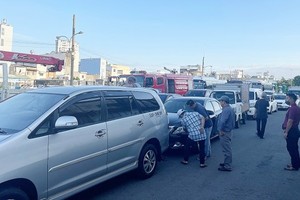 Drivers are checking their vehicles before proceeding with the registration process at the Center No.5002S.