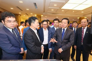 Deputy Prime Minister Tran Hong Ha is visiting the exhibition and discussing with other delegates in the Summit (Photo: SGGP)