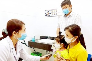 Level-2 Specialist Pham Thi Kieu Diem from Children Hospital No.1 is treating a child 