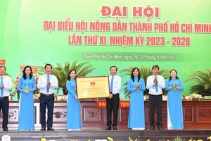 Secretary Nguyen Van Nen of the HCMC Party’s Committee is delivering the board with the line ‘HCMC Farmers for Solidarity – Innovation – Civilization – Development’ from the city Party’s Committee, People’s Committee, People’s Council, HCMC Vietnam Fatherland Front (Photo: SGGP)