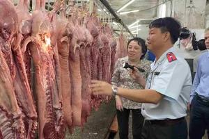 Director Pham Khanh Phong Lan of the newly established HCMC Department of Food Safety is checking pork sold at Binh Dien Wholesale Market 