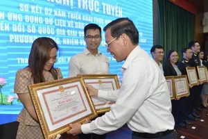 Chairman Phan Van Mai of the HCMC People’s Committee is delivering certificates of merits to individuals and groups with outstanding achievements (Photo: SGGP)