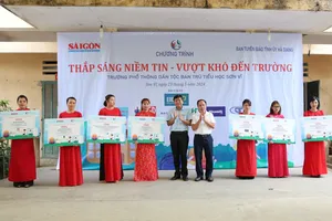 Journalist Tang Huu Phong is handing over money and items to serve the daily life of students to Principal Nguyen Hai Ha of Son Vi Ethnic Boarding Primary School (Photo: SGGP)