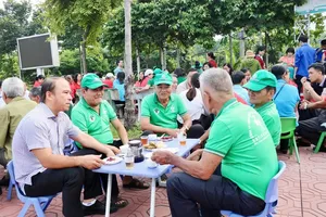 Chairman Vo Chi Thanh of Binh Duong Ward People’s Committee (left) has arrived early to chat with elderly residents of the neighborhood (Photo: SGGP)