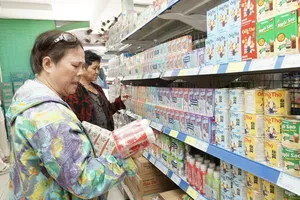 A consumer is selecting Vinamilk dairy products at a store in Thu Dau Mot Ward of HCMC (Photo: SGGP)