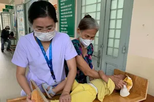 A staff member at the An Hoi Tay Ward Health Clinic in HCMC is measuring a child before their health screening