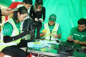 VETC employees are assisting a citizen with the traffic account conversion at a toll station on the HCMC – Long Thanh – Dau Giay Expressway (Photo: SGGP)