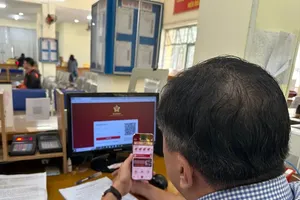 An official at Thong Tay Hoi Ward in HCMC is processing a construction permit application submitted by a resident via the online system