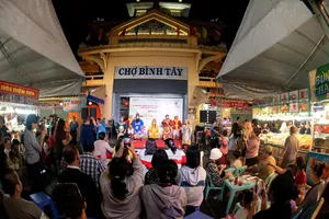 A Hat Boi performance serving the public in front of the gate of Binh Tay Market in HCMC 