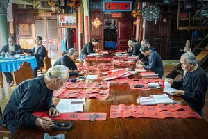 Elders and local officials are gathering at Long Son Big House to smooth “do” paper, grind ink, and write red couplets (Photo: SGGP)