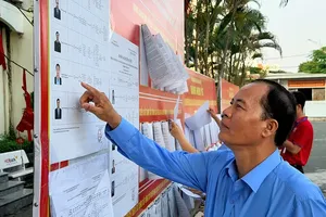 Voters in Tan An Hoi Commune are studying the summary biographies and action programs of the candidates (Photo: SGGP)