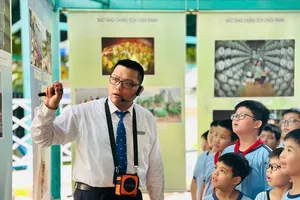Students at Nguyen Van Lich Primary School (Linh Xuan Ward) are listening to a presentation on the thematic exhibition “The Soldier of Today”