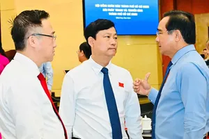 Chairman Nguyen Van Duoc of the HCMC People’s Committee is conversing with Chairman Vo Van Minh of the HCMC People’s Council and Deputy Secretary Dang Minh Thong of the HCMC Party Committee at the regular year-end session of the HCMC People’s Council in 2025 (Photo: SGGP)