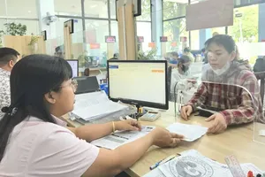 An official at the Public Administration Service Center of An Phu Dong Ward is guiding a citizen through administrative procedures (Photo: SGGP)