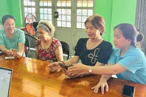 A dedicated specialist from the Thai My Public Administration Service Center is passionately advising a resident on online procedures in Binh Ha Dong hamlet (Photo: SGGP)
