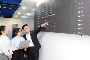 Financial data analysts at the Vietnam International Finance Center in HCMC are monitoring the market in real time (Photo: SGGP)