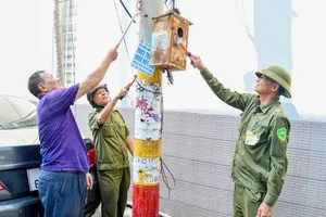 Grassroots security forces and residents of Tam Thang Ward are eradicating illegal advertisements (Photo: SGGP)