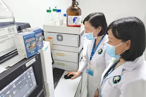 Dr Duong Hong To Quyen (on the right) and her associates at the medicinal materials analysis laboratory (Photo: SGGP)