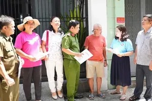 Head Lam Quynh Hoa (second from the right) of Neighborhood No.5 in Dien Hong Ward is providing detailed information regarding the comprehensive neighborhood restructuring scheme to eager citizens (Photo: SGGP)