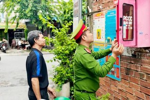 Mr. Tran Van Ro, Head of a Joint-Family Fire Safety Group, alongside Dong Hung Thuan Ward Police, is thoroughly inspecting firefighting equipment (Photo: SGGP/Nguyen Tan)