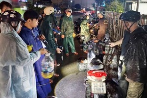 Vo Trung Tin, alongside the An Phu Dong Ward Citizen Support Team in HCMC, is repairing a motorbike to help a citizen (Photo: SGGP/Nguyen Tan)