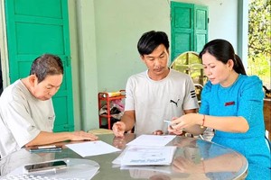 A specialist from the Chau Duc Commune Public Administration Service Center (HCMC) is visiting a home to support a citizen in resolving administrative procedures (Photo: SGGP/Duc Chau)