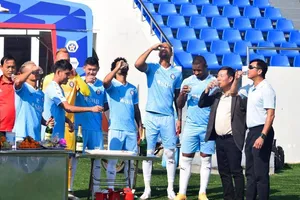 Toàn đội cùng uống ky rượu mừng Xuân ở đầu buổi tập. Ảnh: Viết Định