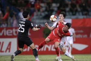 Bùi Tiến Dũng nỗ lực ngăn chận pha uy hiếp khung thành của Văn Toàn (Nam Định). Ảnh: MINH HOÀNG