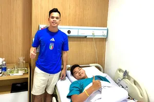 Bác sĩ đội tuyển Việt Nam, ông Trần Huy Thọ bên cạnh Hiểu Minh tại bệnh viện.