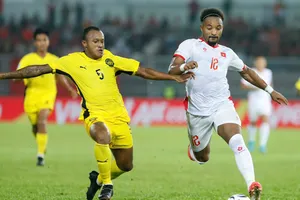 Rodney Celvin (áo vàng) của Malaysia tranh bóng với Xuân Son ở trận lượt đi (Ảnh: ANH KHOA)