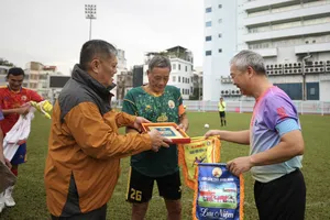 Ông Dương Ngọc Hùng trao tặng quà và cờ lưu niệm đến cầu thủ hai đội. Ảnh: DŨNG PHƯƠNG
