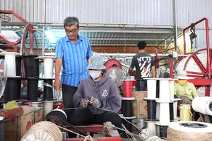 Ông Hùng tận tay hướng dẫn người lao động tại cơ sở về việc đánh dây thừng.