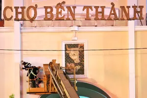Công nhân thi công sơn, chỉnh trang mặt tiền chợ Bến Thành trong đêm, tranh thủ thời gian hoàn thiện các hạng mục trước năm mới. (ẢNH: HOÀNG HÙNG)