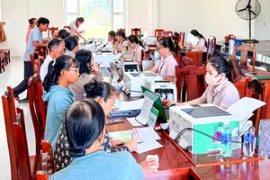 Thực hiện thủ tục giải ngân cho người vay vốn. Ảnh: THÀNH HUY