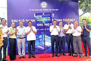Lãnh đạo phường phường Tân Thới Hiệp cùng các đại biểu thực hiện nghi thức ra mắt "Khu phố thanh toán không dùng tiền mặt". ẢNH: THANH DUNG 