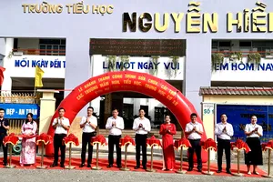 Lãnh đạo phường Bình Trưng và đại diện các trường học thực hiện nghi thức cắt băng khánh thành. Ảnh: HỒ SƠN