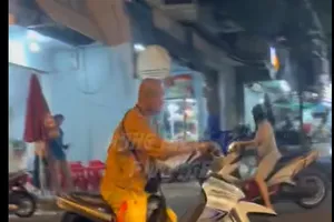 Một người mặc áo nhà tu chạy xe máy lạng lách, đánh nhau với người đi đường