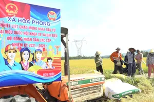 Nông dân xã Hòa Phong tuyên truyền bầu cử trên đồng ruộng