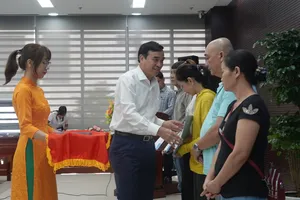 Ông Lê Trung Chinh, Chủ tịch UBND TP Đà Nẵng trao quyết định cho các hộ nghèo có hoàn cảnh đặc biệt khó khăn. Ảnh: XUÂN QUỲNH