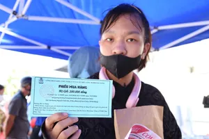 Mỗi thanh niên công nhân được Công đoàn Khu công nghệ cao và các khu công nghiệp Đà Nẵng phát phiếu mua hàng tại ngày hội. Ảnh: XUÂN QUỲNH