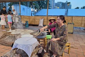 Du khách trải nghiệm làm bánh tráng Túy Loan tại Lễ hội du lịch ở Đà Nẵng. Ảnh: XUÂN QUỲNH