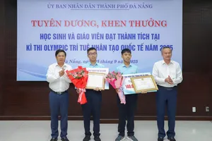 Ông Lương Nguyễn Minh Triết, Chủ tịch UBND TP Đà Nẵng và ông Đoàn Ngọc Hùng Anh, Phó Chủ tịch HĐND TP Đà Nẵng trao thưởng và tặng hoa chúc mừng 2 học sinh