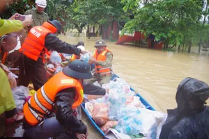 Cán bộ, chiến sĩ Vùng 3 Hải quân chuyển lương thực, nước uống xuống xuồng nhỏ để chuyển đến tay người dân