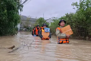 Các chiến sĩ lội nước vận chuyển nhu yếu phẩm hỗ trợ người dân