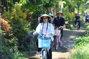 Du khách đạp xe dạo quanh làng cổ Lộc Yên, khám phá nét bình yên và cảnh sắc mộc mạc của vùng quê xứ Quảng. Ảnh: XUÂN QUỲNH