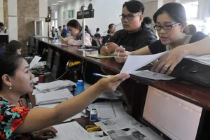 Doanh nghiệp nêu thắc mắc với nhân viên Cục Thuế TPHCM.  Ảnh: CAO THĂNG