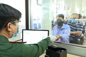 Người dân xếp hàng thực hiện các thủ tục theo quy định  tại Cửa khẩu Quốc tế Lao Bảo. Ảnh: NGUYỄN HOÀNG