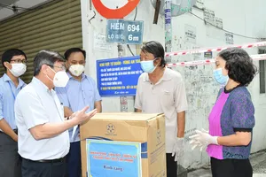 Chủ tịch UBND TPHCM Nguyễn Thành Phong trao quà hỗ trợ người dân ở "vùng xanh" tại quận Phú Nhuận. Ảnh: VIỆT DŨNG